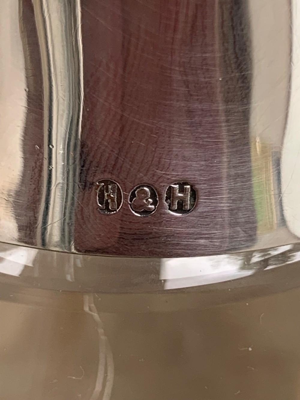 A clear spherical glass claret jug featuring a silver-plated collar, flat hinged cap, angular handle, and a cut starburst pattern on the base. View VIII