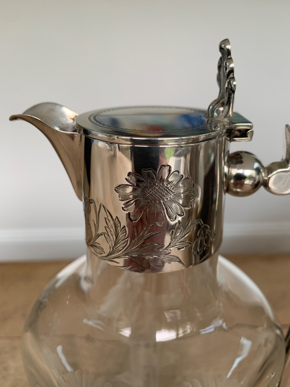 An Edwardian clear glass claret jug featuring wheel-engraved daisy motifs and a hallmarked sterling silver collar with handle. View III