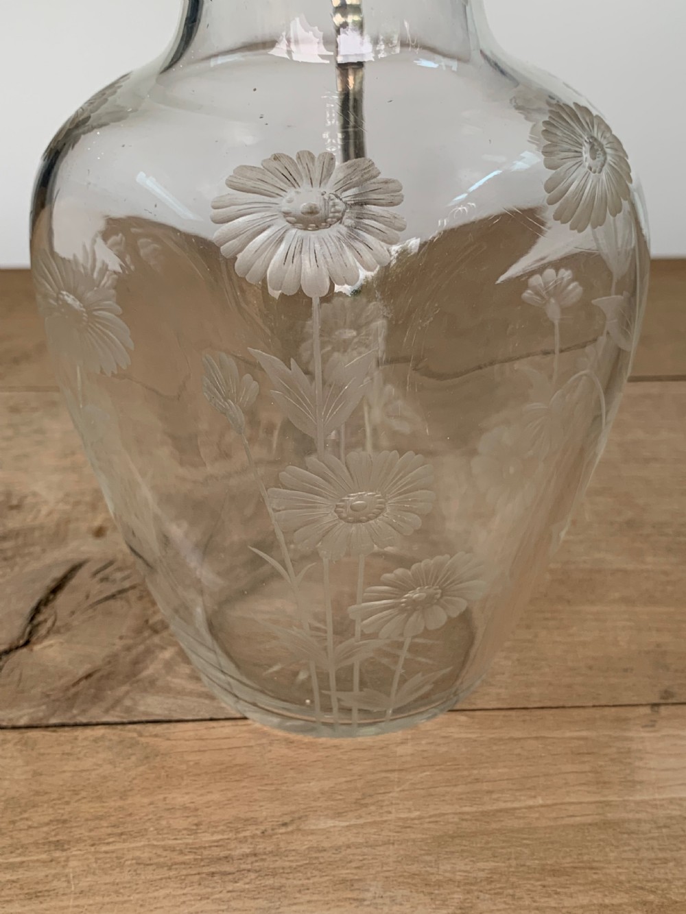 An Edwardian clear glass claret jug featuring wheel-engraved daisy motifs and a hallmarked sterling silver collar with handle. View XI