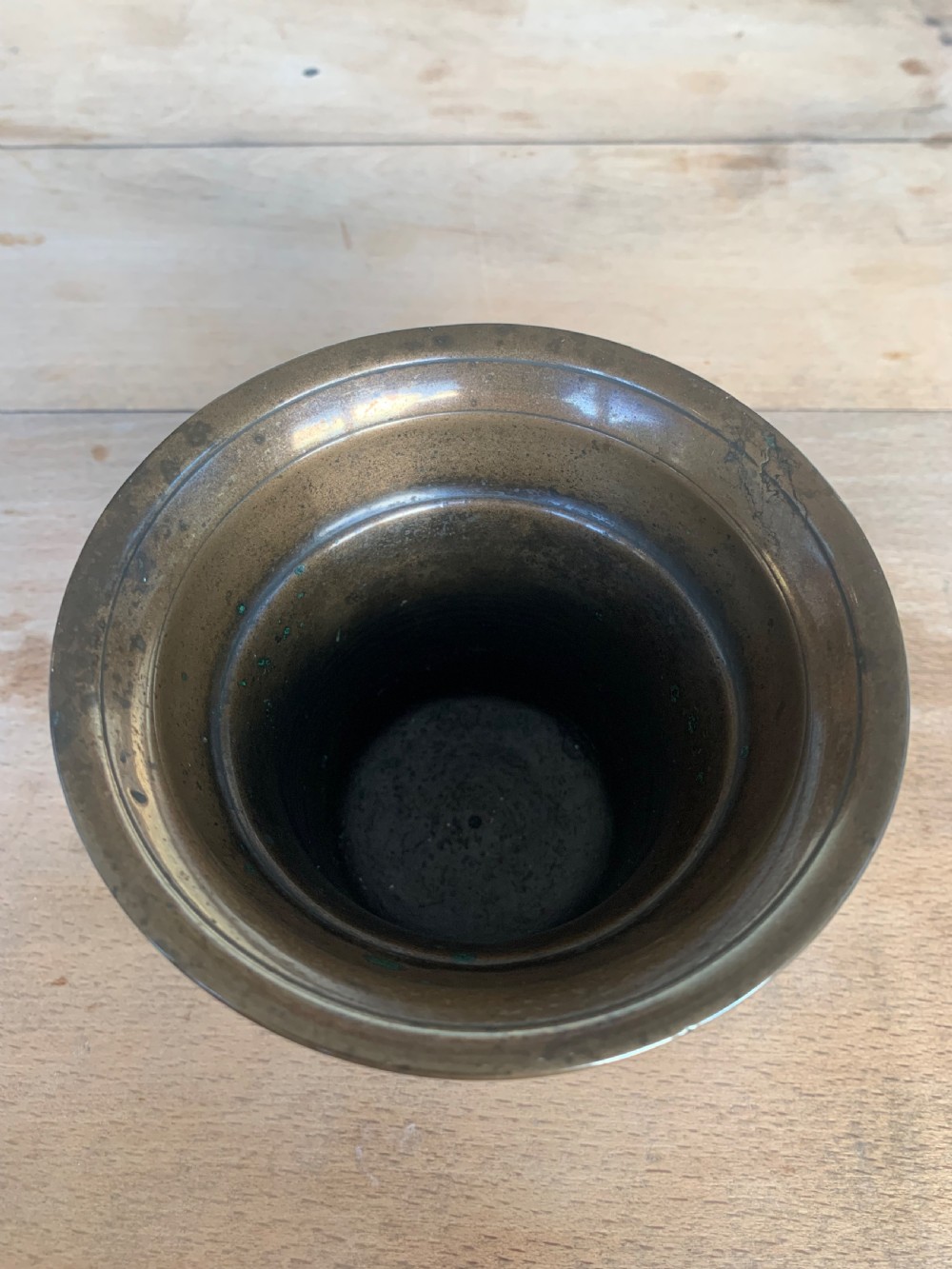 An antique cast bronze mortar with a flared rim and turned waist, accompanied by a matching metal pestle. View V