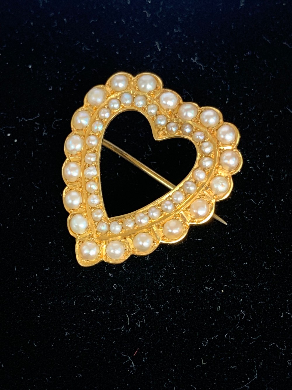 A Victorian 18ct yellow gold heart brooch featuring a double border of set seed pearls around an open centre. View III