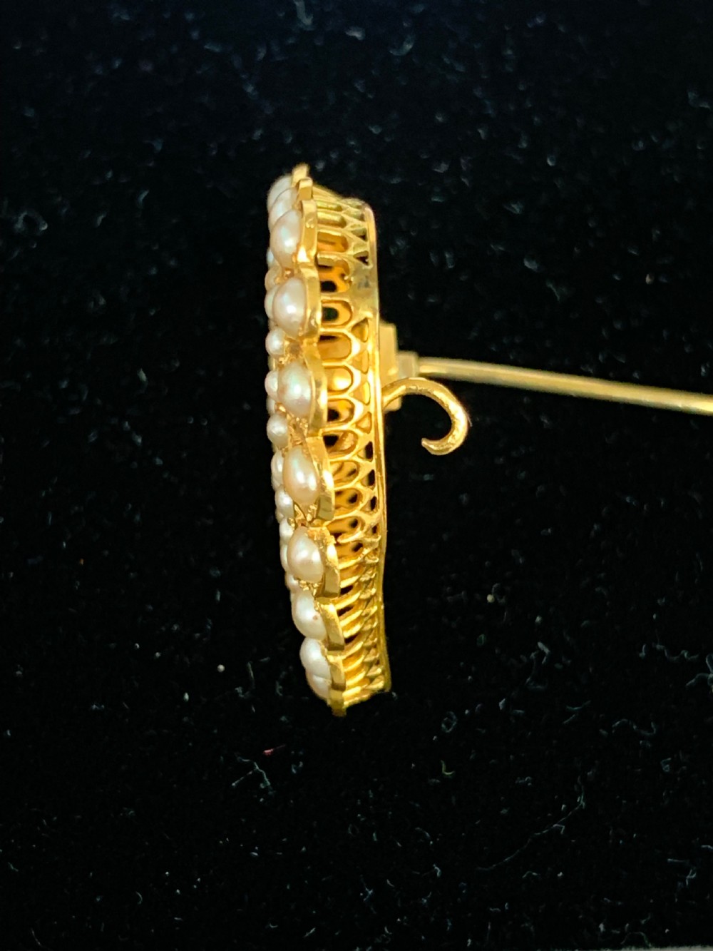 A Victorian 18ct yellow gold heart brooch featuring a double border of set seed pearls around an open centre. View VI