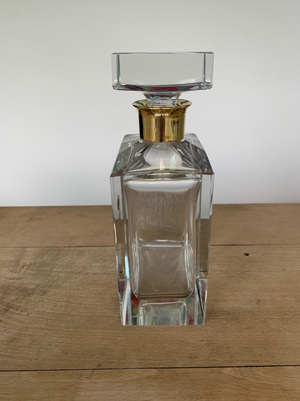 A square clear crystal brandy decanter featuring a silver-gilt collar around the neck, a crowned N monogram on the body, and a rectangular stopper. View II