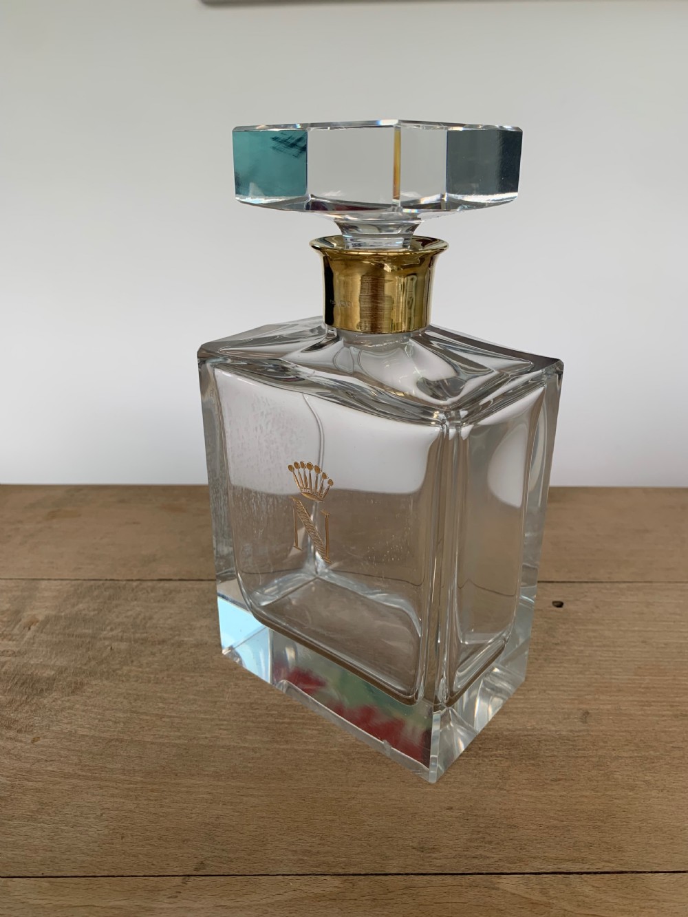 A square clear crystal brandy decanter featuring a silver-gilt collar around the neck, a crowned N monogram on the body, and a rectangular stopper. View V