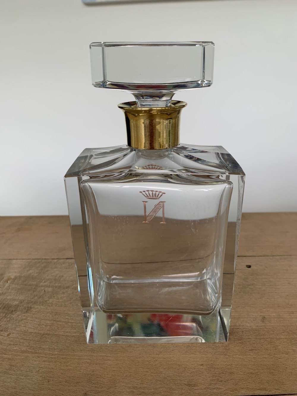A square clear crystal brandy decanter featuring a silver-gilt collar around the neck, a crowned N monogram on the body, and a rectangular stopper. View X