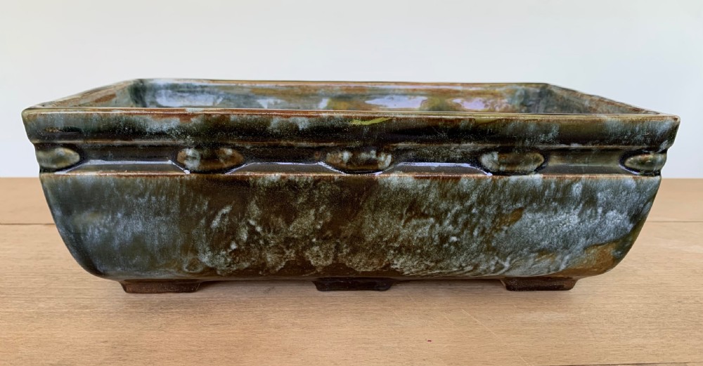 A pair of rectangular stoneware bonsai planters featuring a mottled olive-green drip glaze and embossed beaded rim details. View V