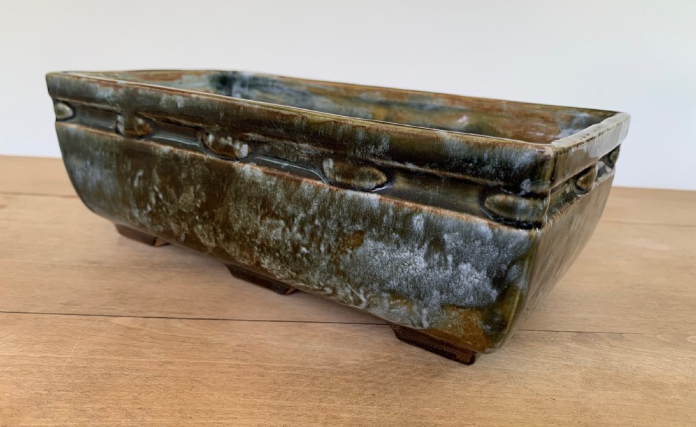 A pair of rectangular stoneware bonsai planters featuring a mottled olive-green drip glaze and embossed beaded rim details. View VII