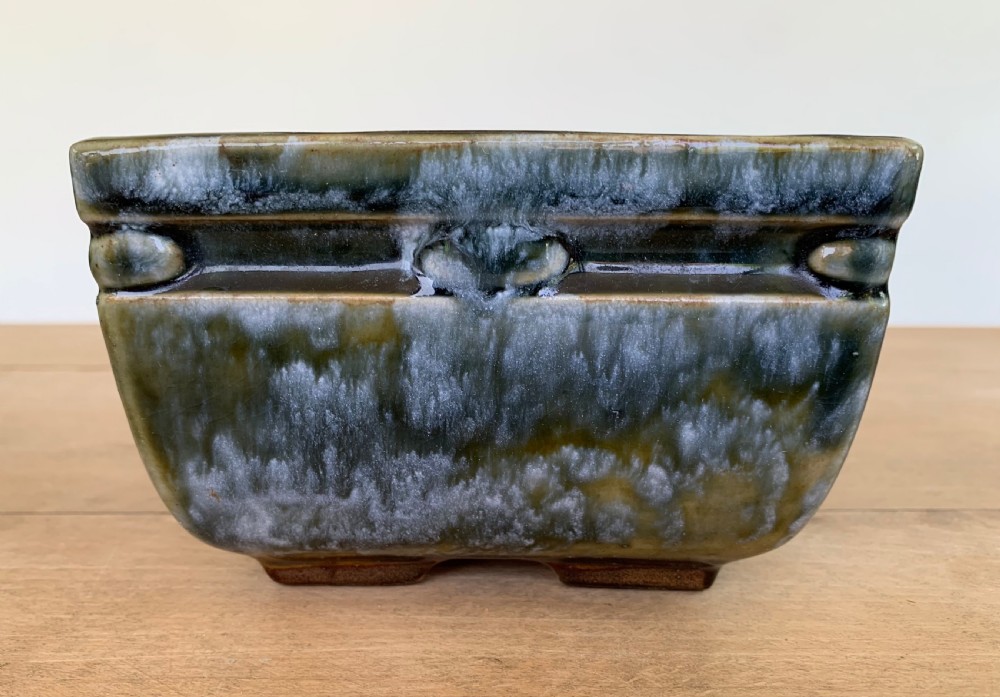 A pair of rectangular stoneware bonsai planters featuring a mottled olive-green drip glaze and embossed beaded rim details. View IX