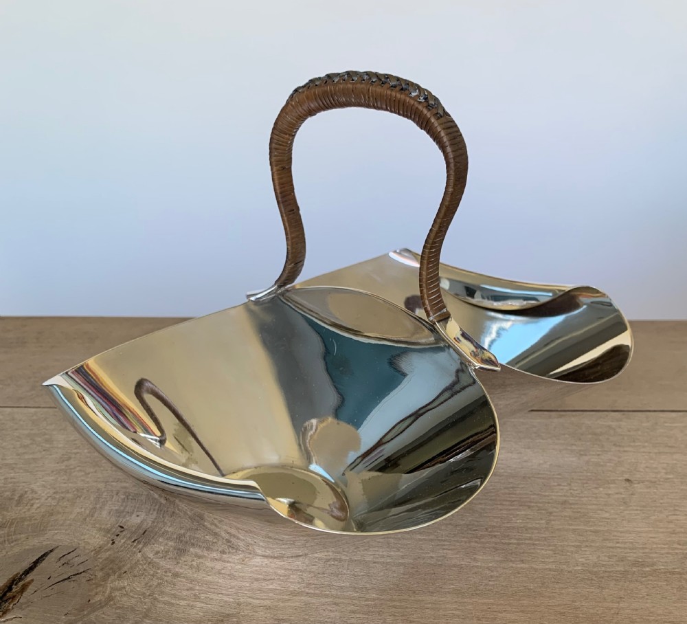 A late Victorian silver-plated twin bon-bon dish with scoop-shaped bowls and a central overhead cane-wrapped arch handle. View II