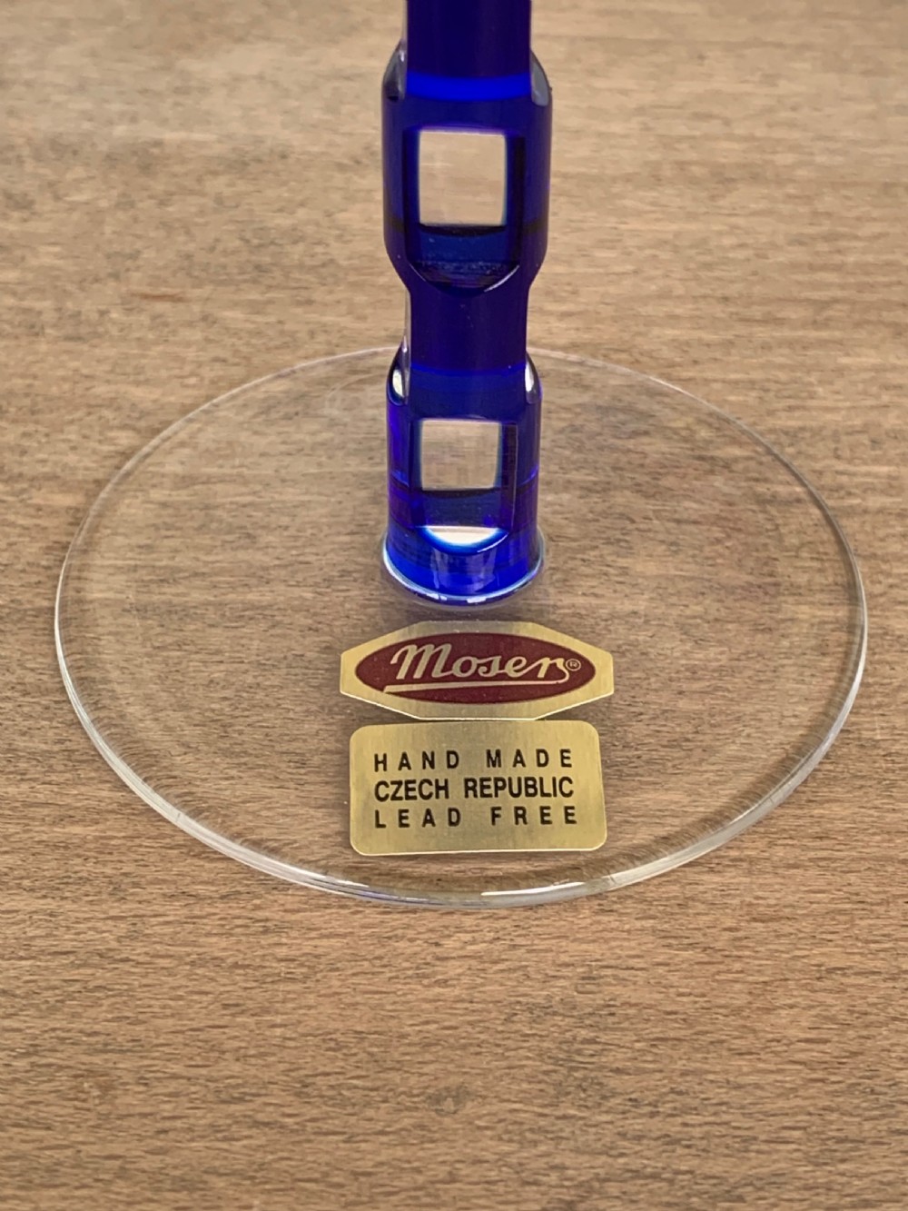 Pair of cobalt blue cut-to-clear crystal champagne flutes featuring geometric architectural patterns and notched square stems on round clear bases. View XIV