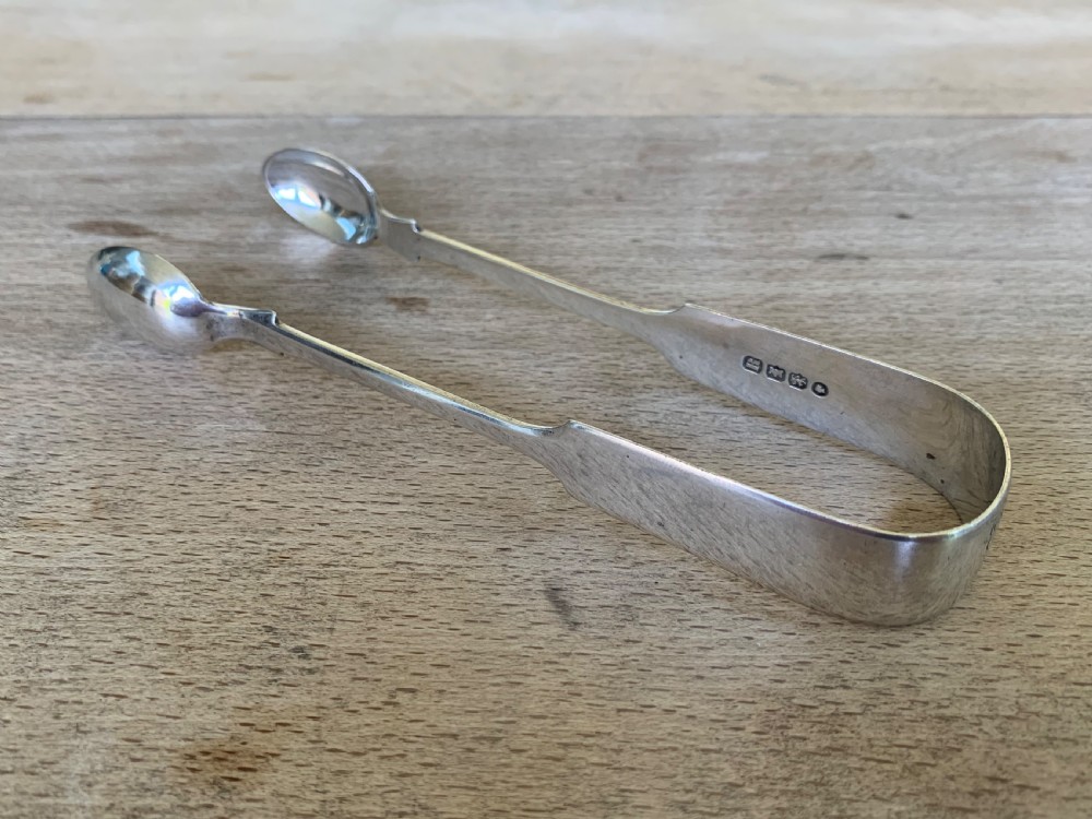 A pair of Victorian sterling silver sugar tongs featuring a plain U-shaped bow and spoon-shaped grips. View III