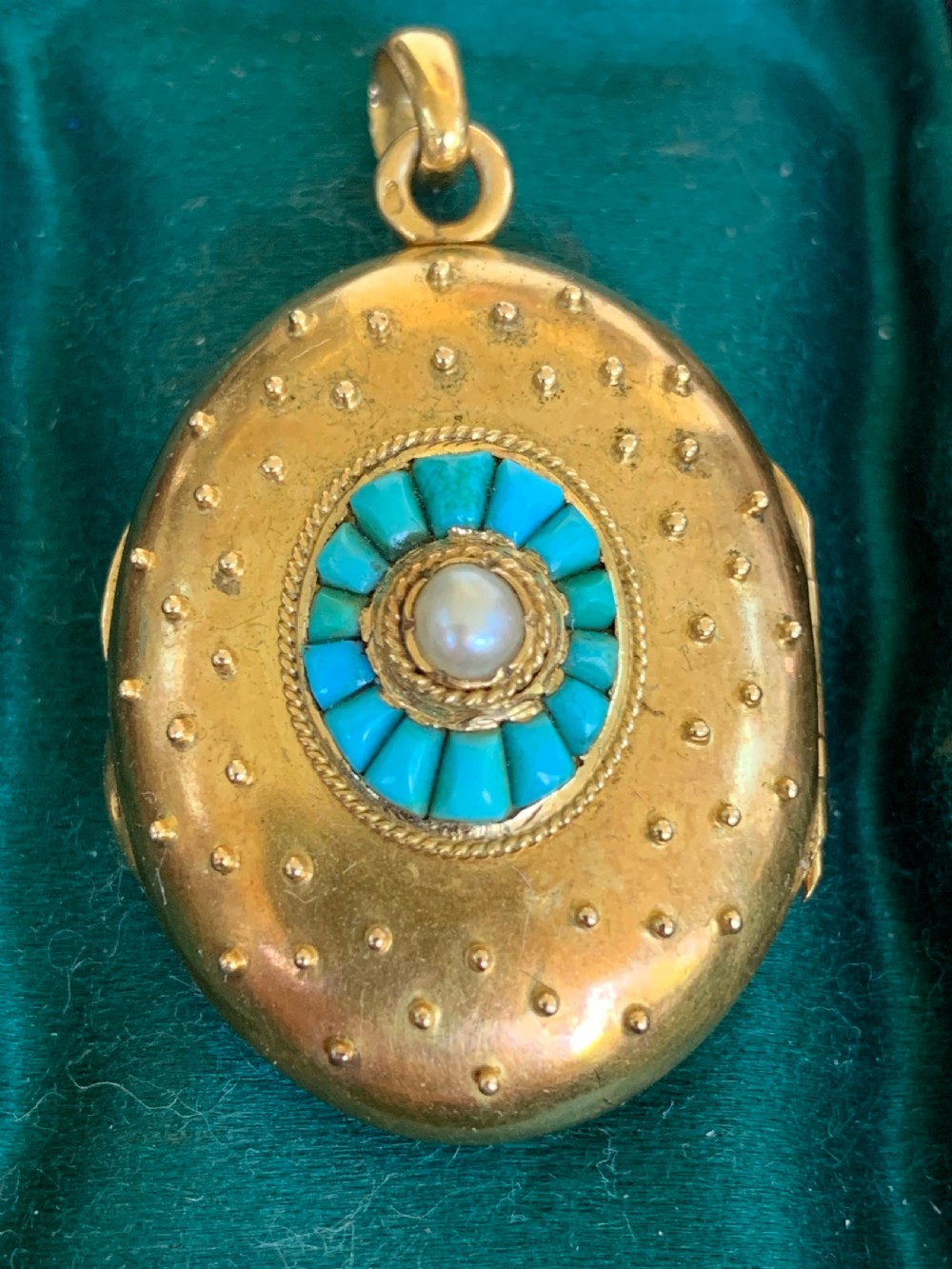 An oval 18ct yellow gold antique photo locket decorated with beaded granulation and a central turquoise and pearl target cluster.