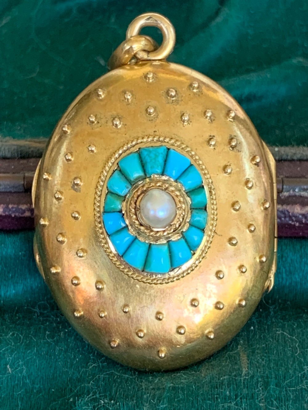 An oval 18ct yellow gold antique photo locket decorated with beaded granulation and a central turquoise and pearl target cluster. View II
