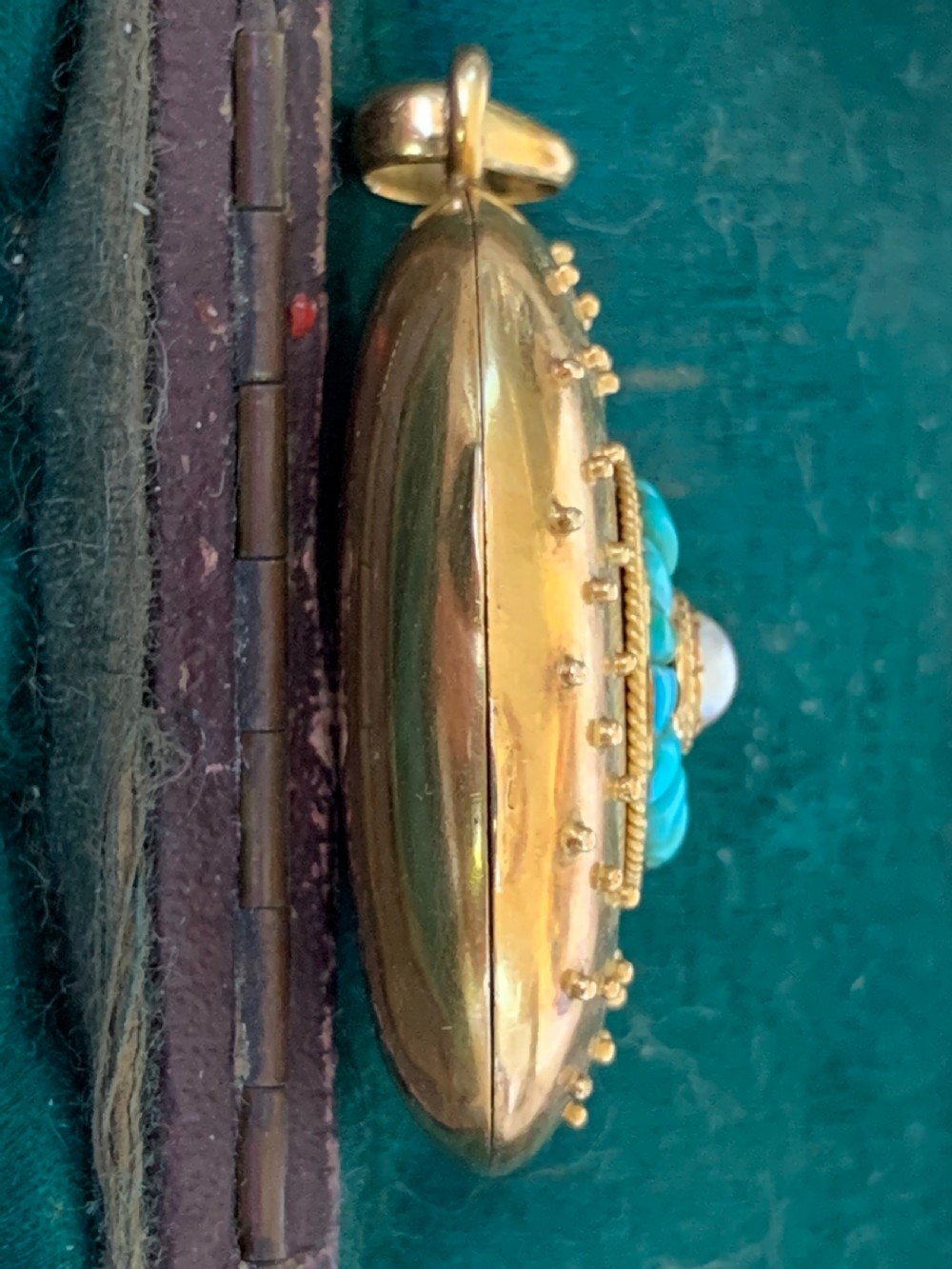 An oval 18ct yellow gold antique photo locket decorated with beaded granulation and a central turquoise and pearl target cluster. View VI
