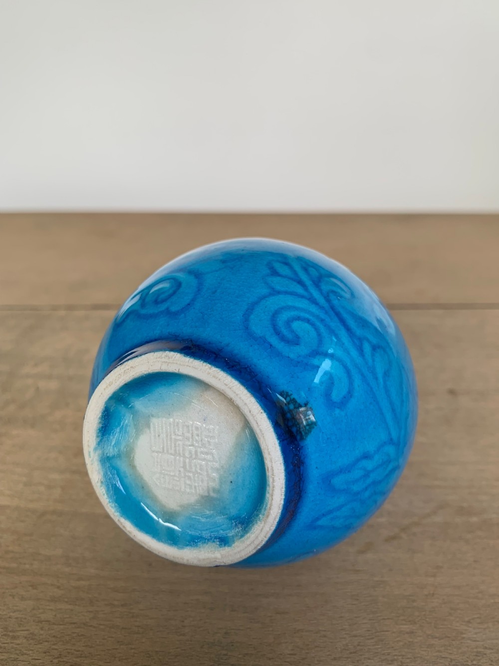 A turquoise blue Chinese porcelain bottle vase featuring a long cylindrical neck, rounded body, and incised peony motifs beneath a glossy glaze. View VII