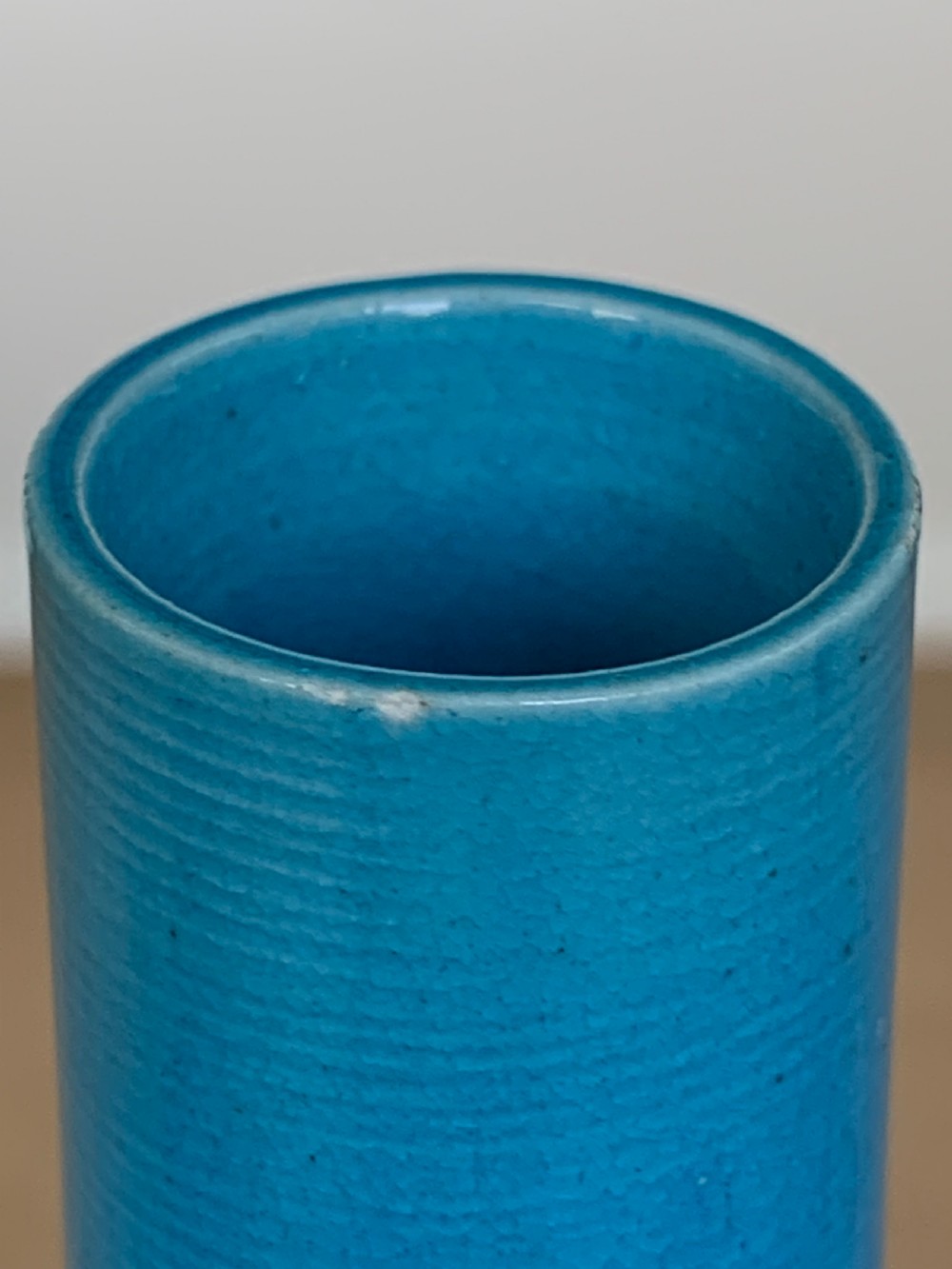 A turquoise blue Chinese porcelain bottle vase featuring a long cylindrical neck, rounded body, and incised peony motifs beneath a glossy glaze. View X