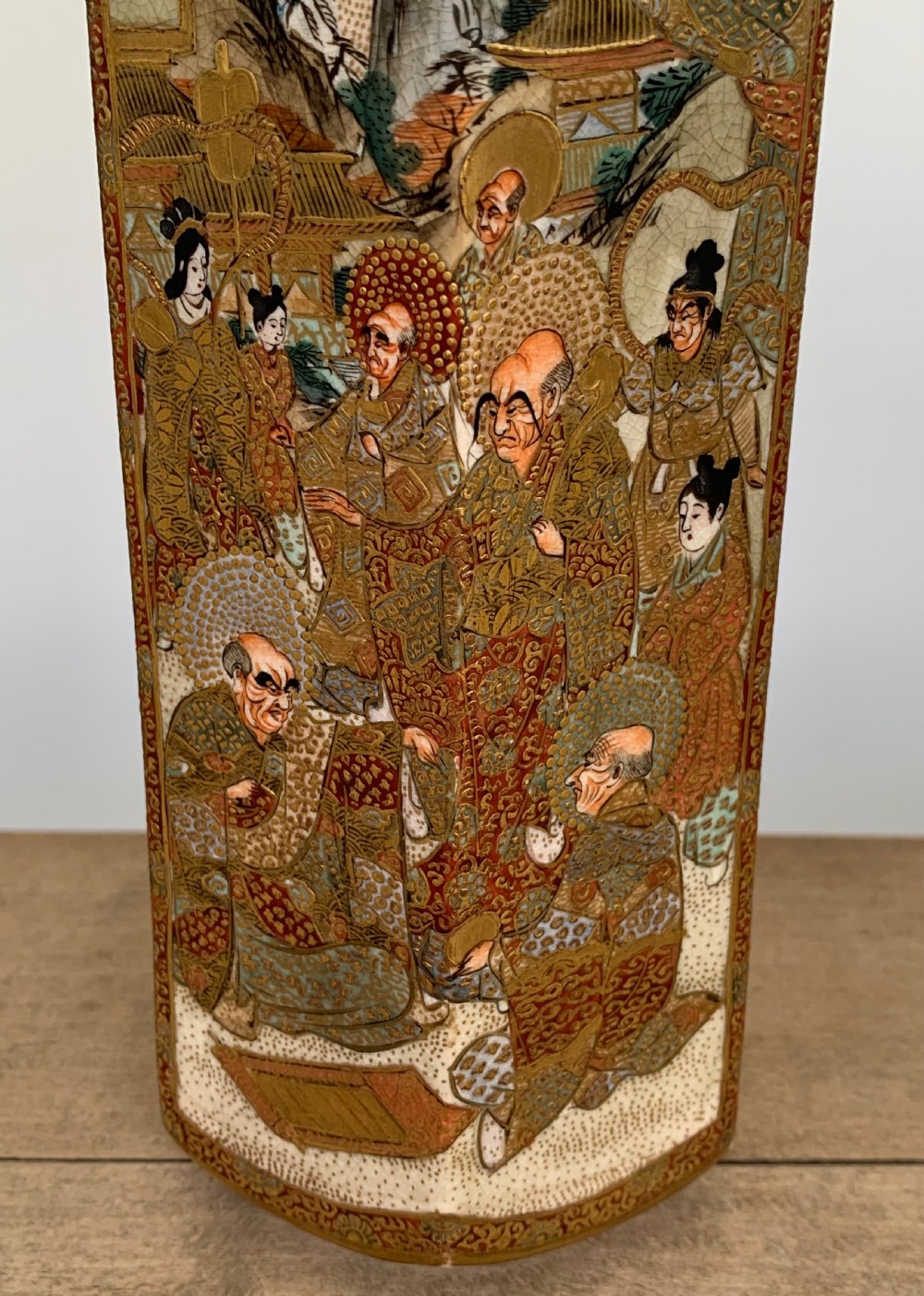 A tall hexagonal Japanese Satsuma ceramic vase with crackle glaze, depicting detailed painted figures in traditional robes and gilded geometric borders. View IV