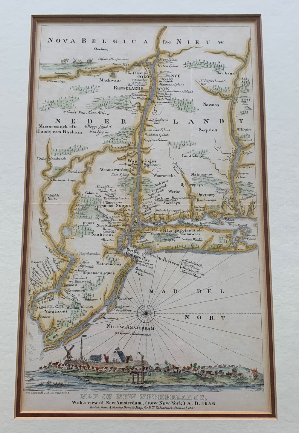 A framed antique map of New Netherlands featuring a detailed compass rose and an inset panorama illustration of early New Amsterdam along the bottom.