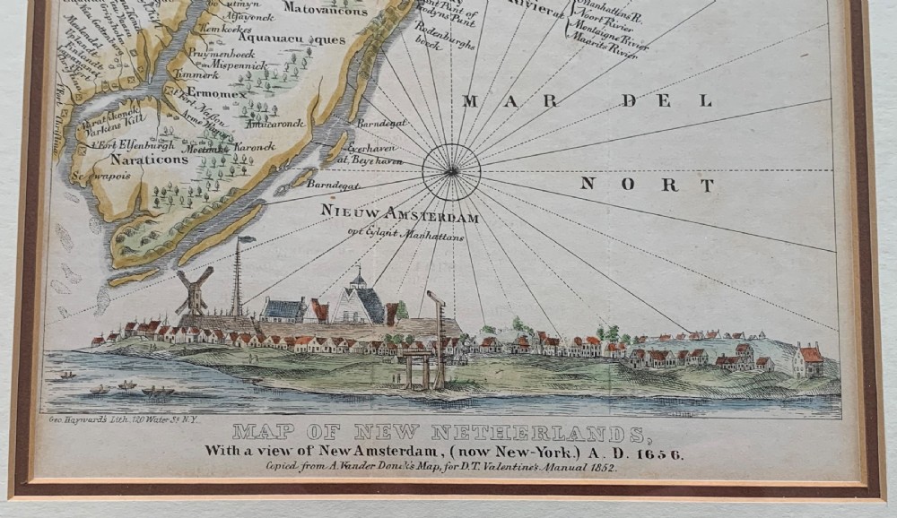 A framed antique map of New Netherlands featuring a detailed compass rose and an inset panorama illustration of early New Amsterdam along the bottom. View V