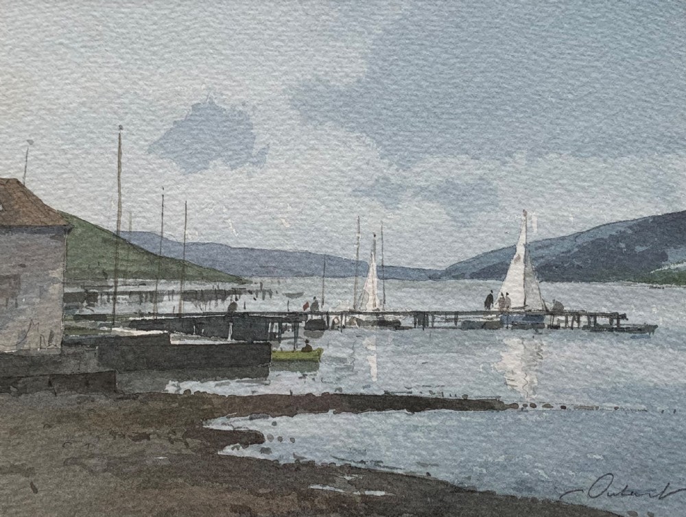 A framed watercolour painting by Stanley Orchart depicting sailboats, jetties, and stone buildings on the shore of Loch Earn under a cloud-filled blue sky. View II
