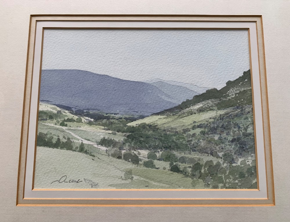 A framed watercolour landscape painting depicting rolling green hills and distant grey mountains near Killin, Scotland, signed by Stanley Orchart.