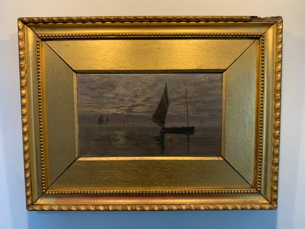 A 19th-century oil painting on board depicting sailing vessels on calm waters under an overcast sky, framed in a wide gilt frame. View VII