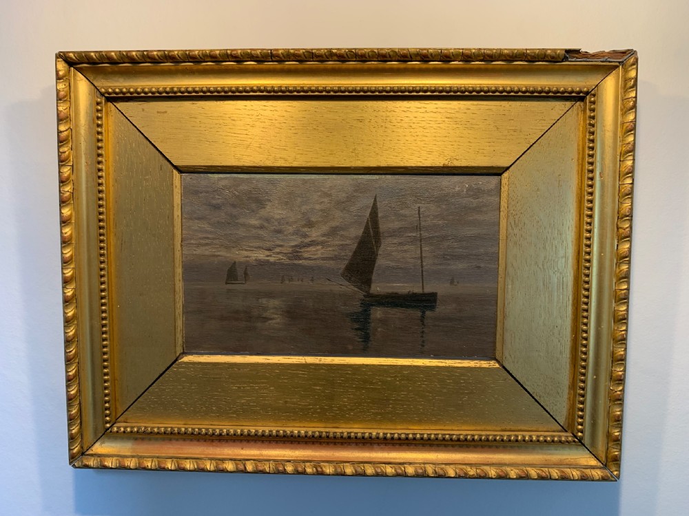 A 19th-century oil painting on board depicting sailing vessels on calm waters under an overcast sky, framed in a wide gilt frame. View VIII