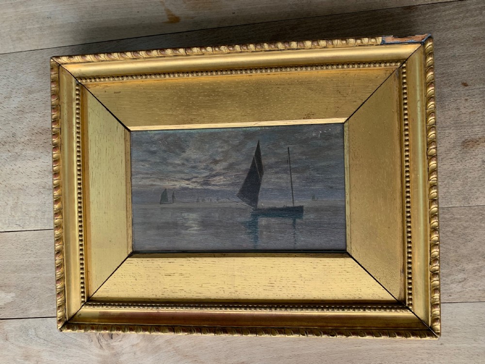 A 19th-century oil painting on board depicting sailing vessels on calm waters under an overcast sky, framed in a wide gilt frame. View XI