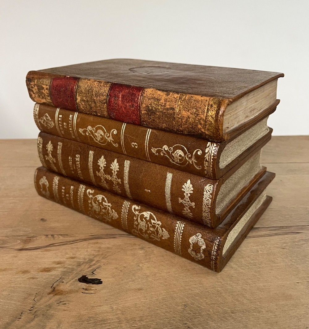 An open vintage warm brown leather box disguised as a stack of two gold-tooled books, featuring a fabric-lined interior with a brass support mechanism. View II