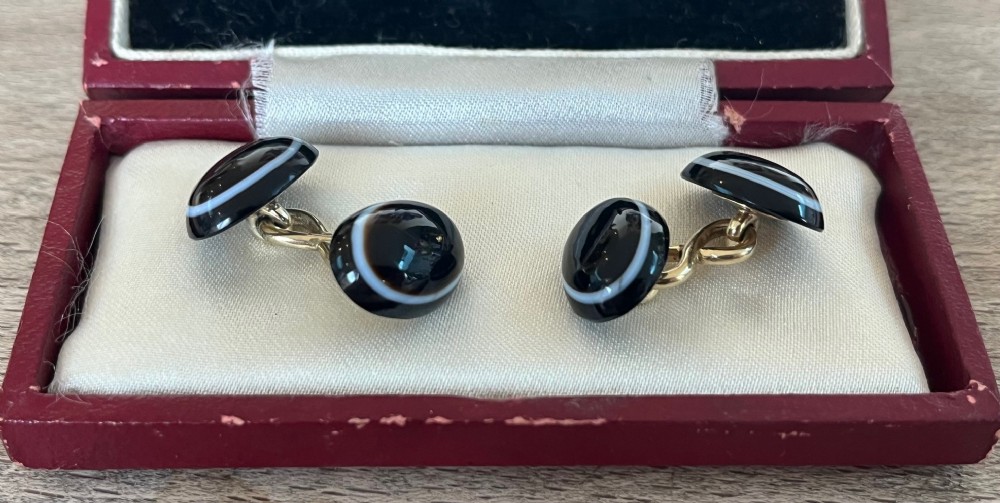 A pair of antique double-ended yellow gold cufflinks set with smooth cabochon-cut black and white banded agate stones.