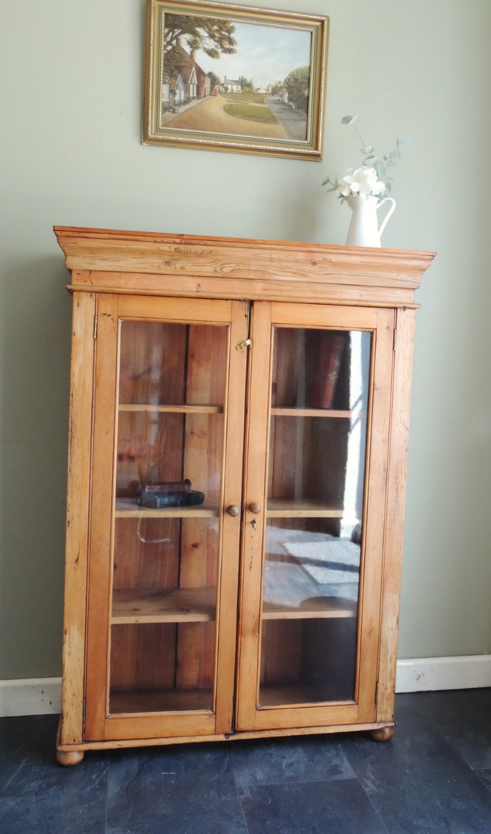A Victorian solid pine glazed display cabinet featuring two full-length glass doors, wooden turned knobs, interior shelves, and a moulded top cornice. View III