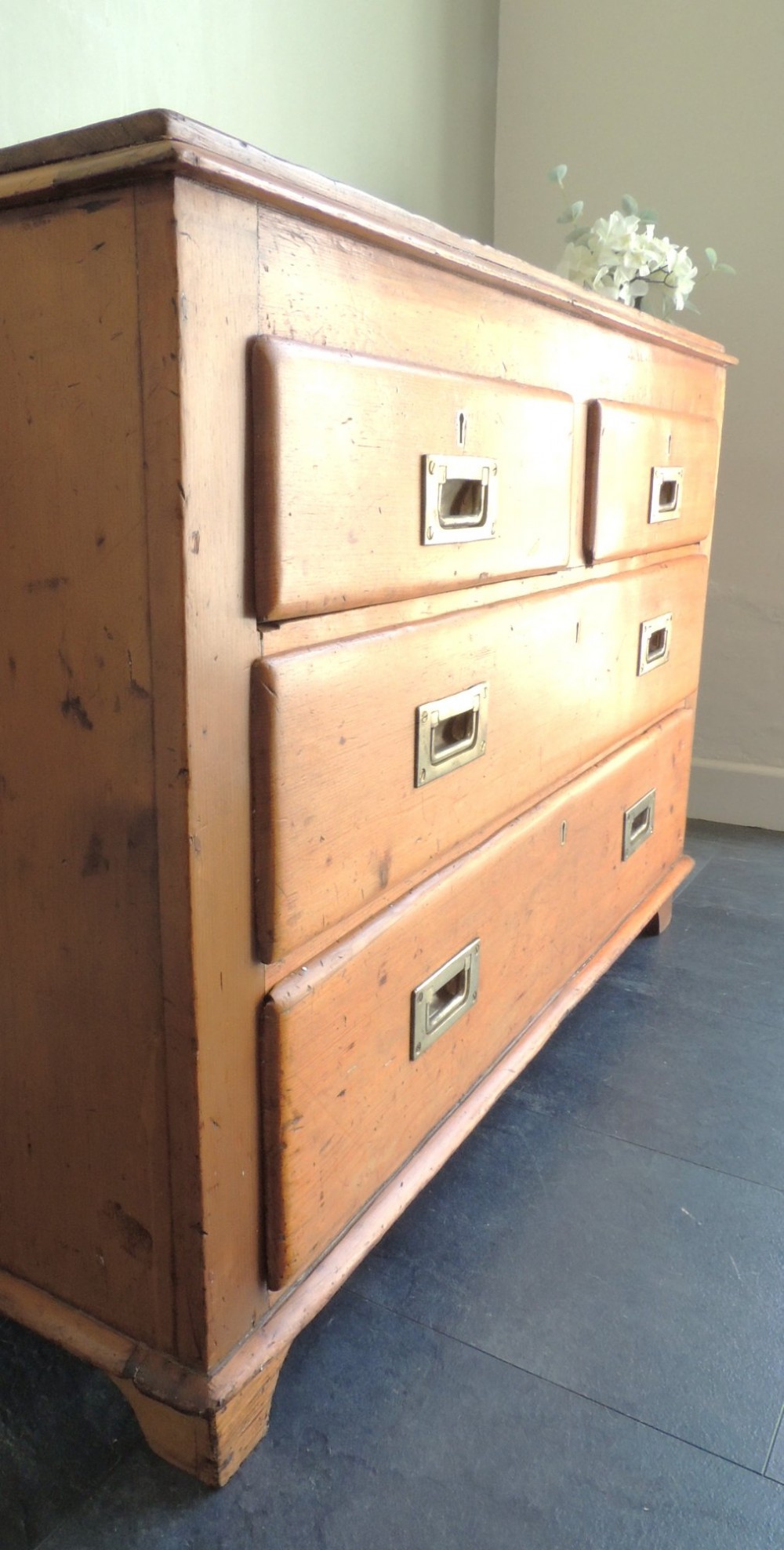 A Victorian solid pine chest of drawers featuring two short drawers over two long drawers fitted with flush brass handles. View II