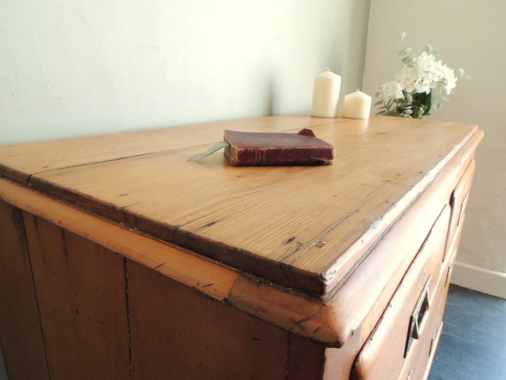 A Victorian solid pine chest of drawers featuring two short drawers over two long drawers fitted with flush brass handles. View V