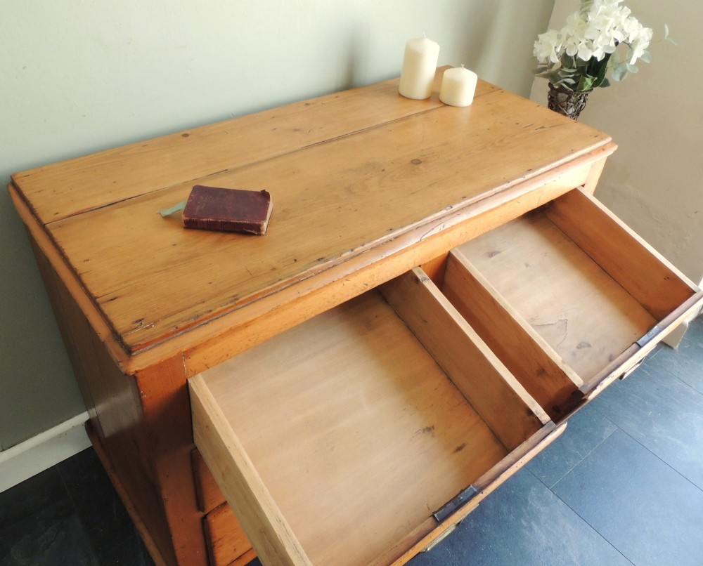A Victorian solid pine chest of drawers featuring two short drawers over two long drawers fitted with flush brass handles. View VII