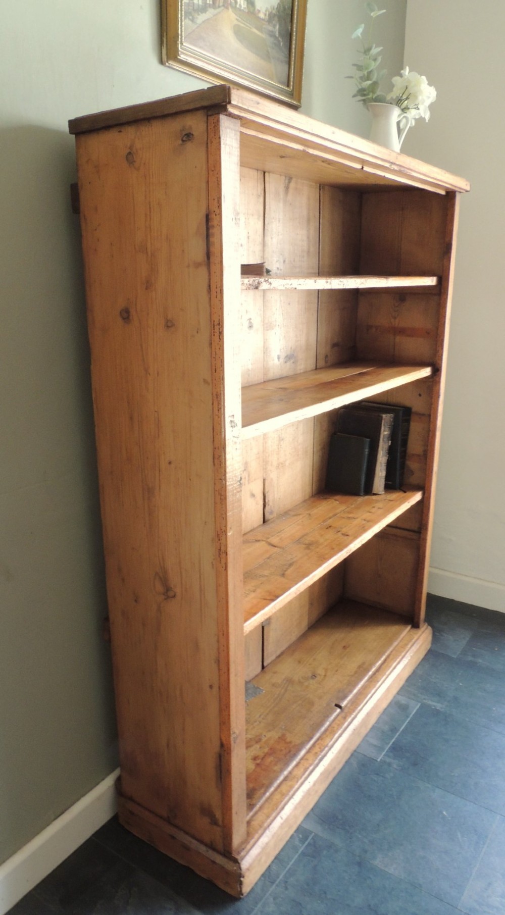 A tall Victorian open-front pine bookcase featuring four spacious shelves and a planked backboard resting on a solid plinth base. View III