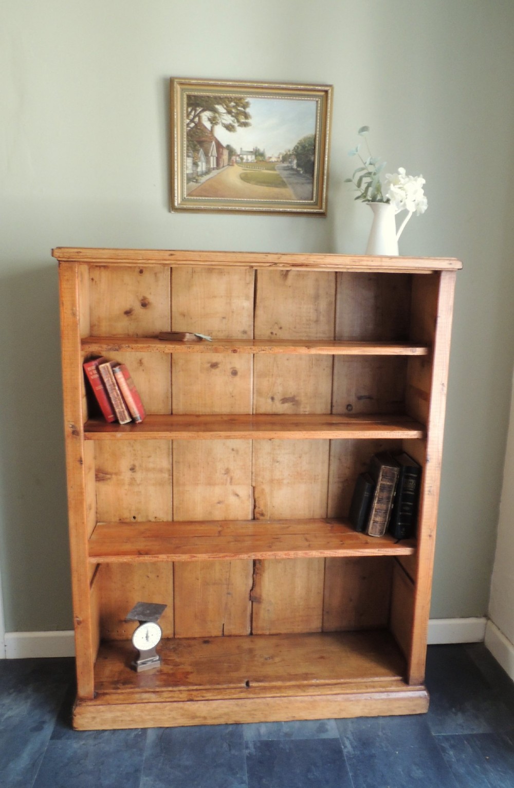 A tall Victorian open-front pine bookcase featuring four spacious shelves and a planked backboard resting on a solid plinth base. View IV