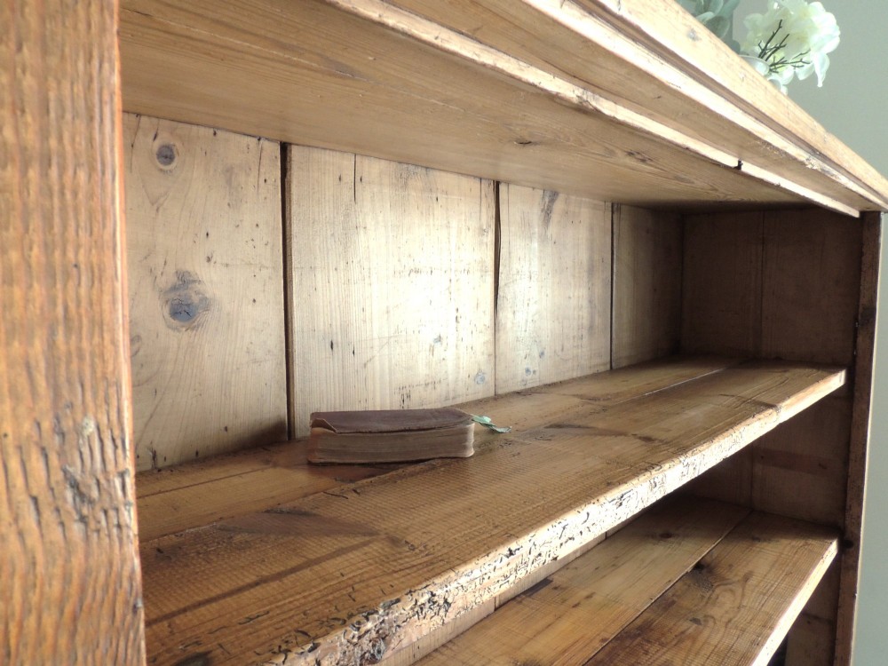 A tall Victorian open-front pine bookcase featuring four spacious shelves and a planked backboard resting on a solid plinth base. View VI