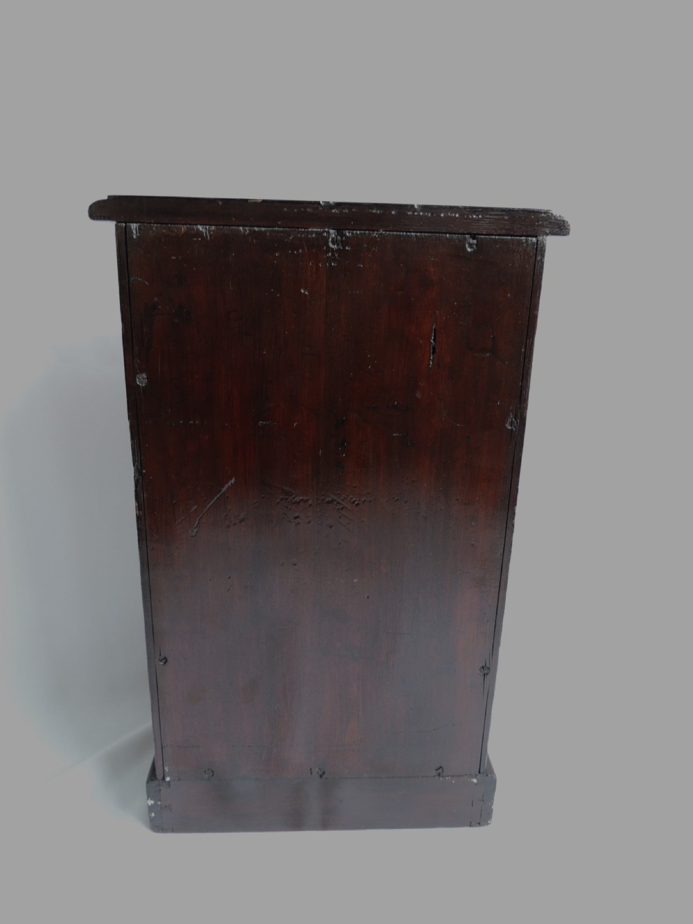 A dark stained pine Victorian miniature chest of drawers featuring six drawers with turned wooden knobs and a shaped plinth base. View X
