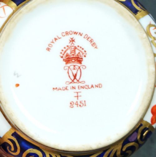 A pair of antique Royal Crown Derby porcelain coffee cans and matching saucers decorated in an Imari pattern with cobalt blue, iron red floral panels, and gold gilding. View II