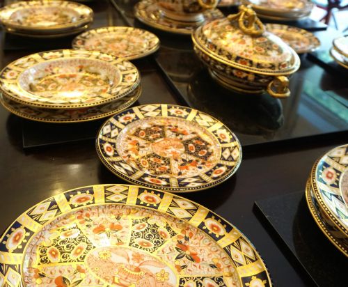 fig 1. An extensive Victorian Davenport Imari pattern porcelain dinner service comprising numerous plates, serving platters, and covered tureens decorated in cobalt blue, orange, and gilt.