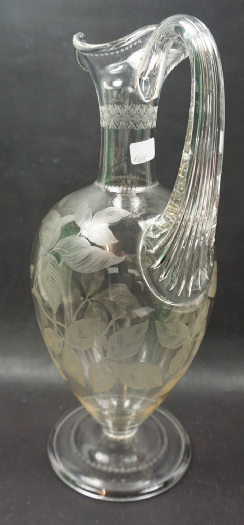 A late nineteenth-century clear lead crystal wine jug featuring wheel-engraved bird and leaf motifs, a flared rim, and a circular pedestal base. View III