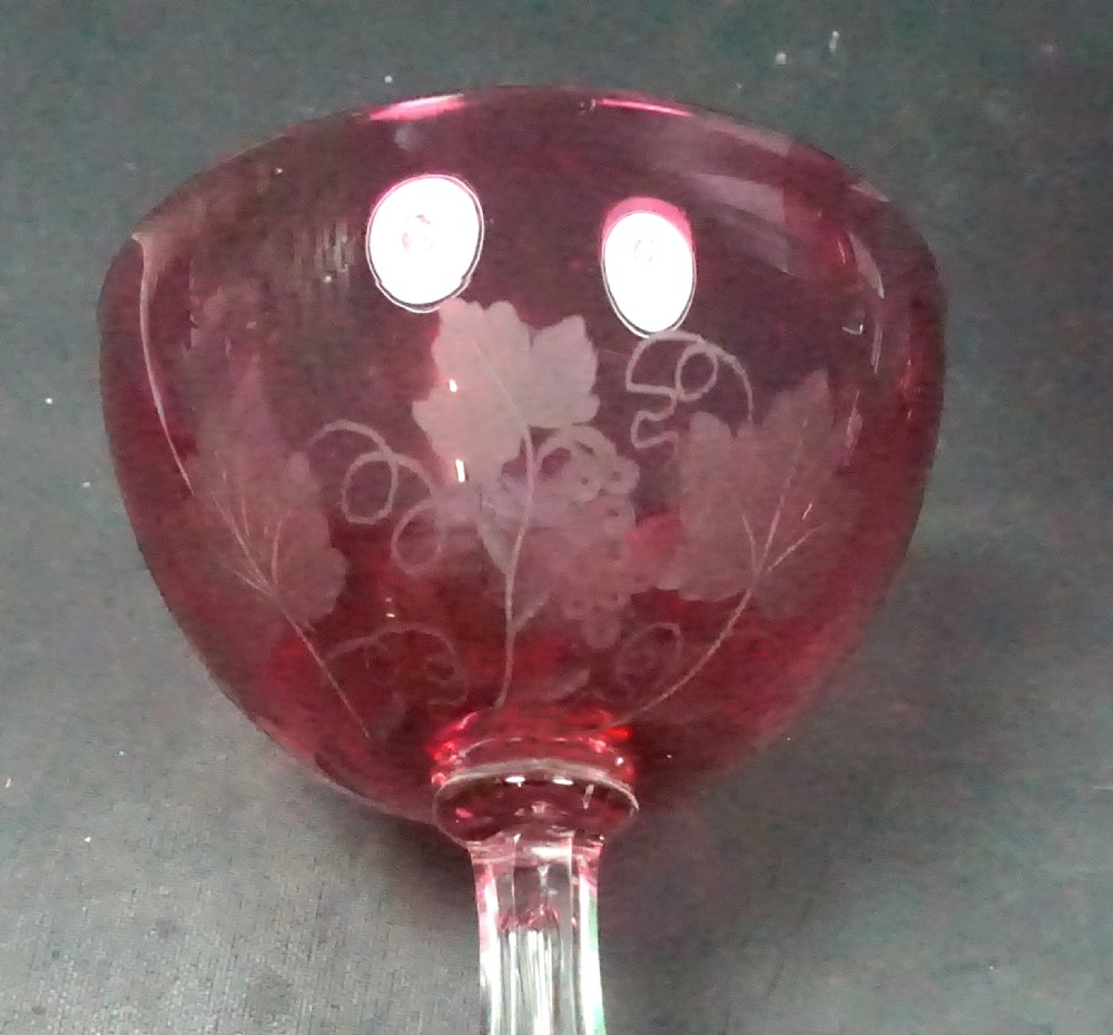 A pair of Victorian ruby red overlay crystal champagne coupes featuring etched fruiting vine motifs on clear knopped stems and circular red bases. View II
