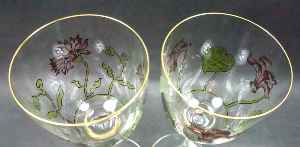 A pair of tall clear crystal hock glasses featuring hand-painted purple floral enamel decorations with green foliage and thin gilt borders. View II