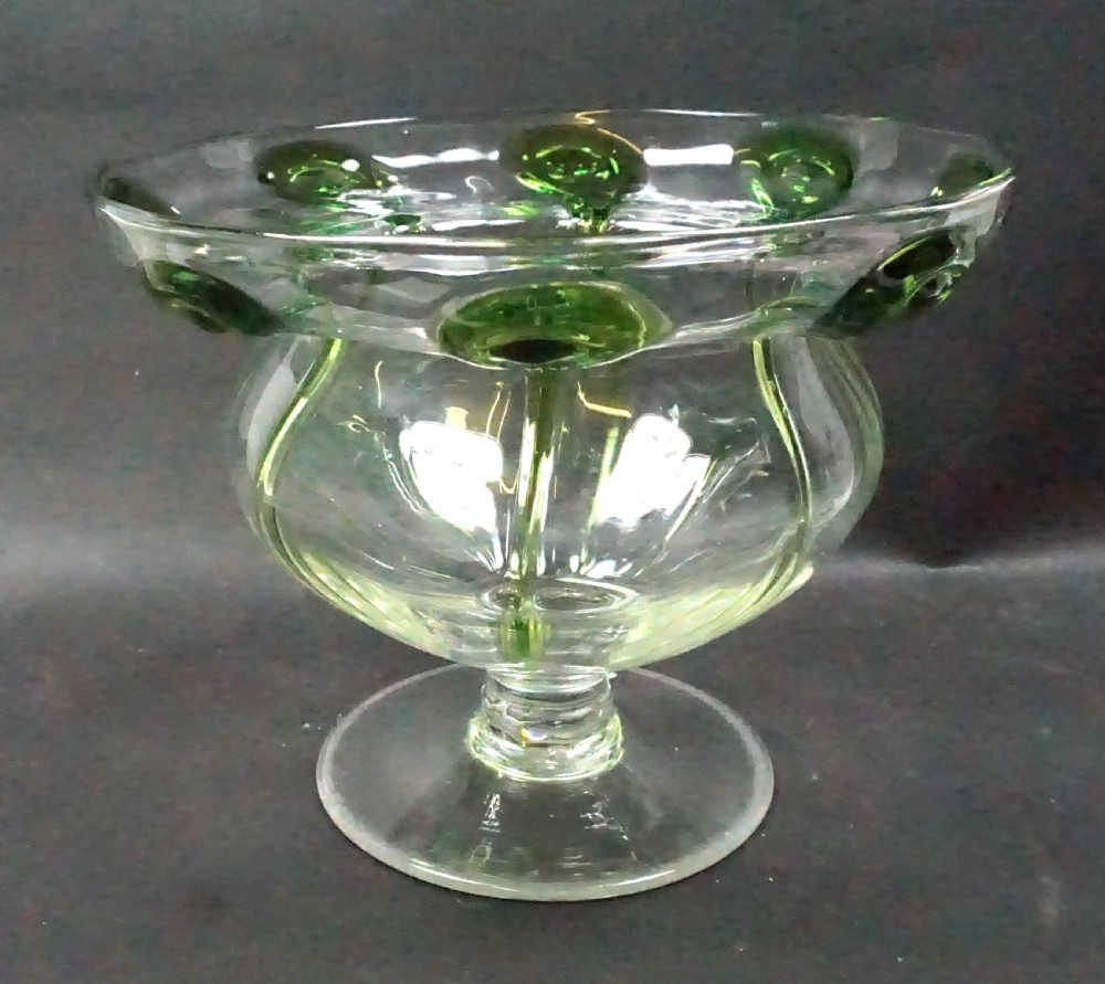 A late nineteenth-century hand-blown clear crystal footed vase featuring a flared rim decorated with applied green glass peacock-eye motifs.
