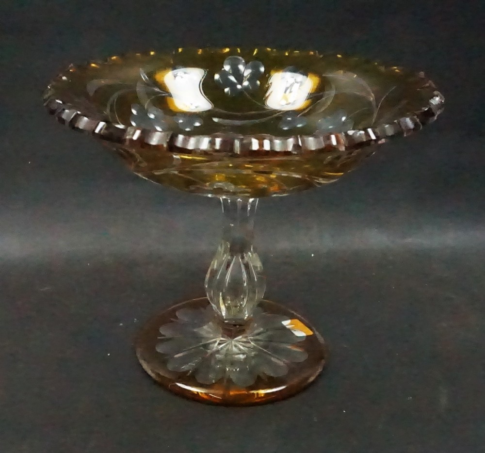 An English mid-nineteenth-century cased yellow glass tazza featuring cut-to-clear floral motifs, a scalloped rim, a faceted stem, and a star-cut foot.