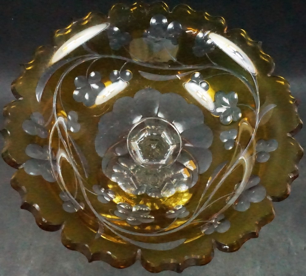 An English mid-nineteenth-century cased yellow glass tazza featuring cut-to-clear floral motifs, a scalloped rim, a faceted stem, and a star-cut foot. View II