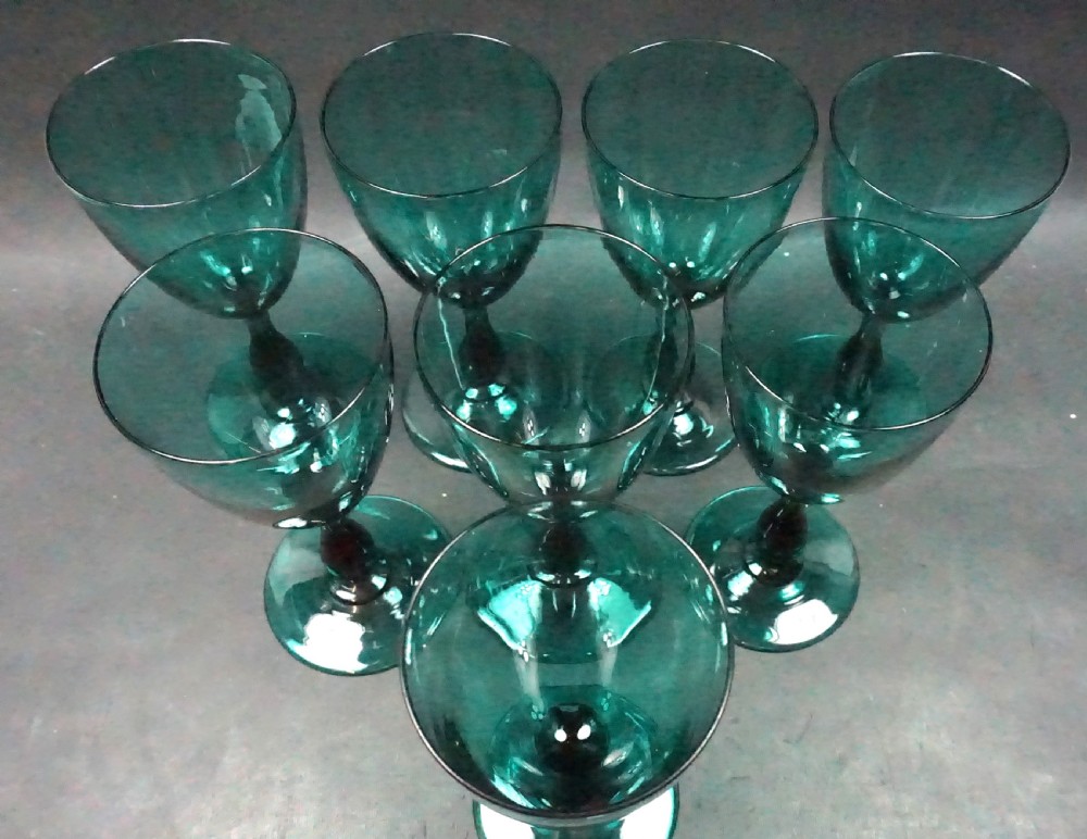 A set of eight emerald green tulip-shaped glass wine goblets with turned stems. View II