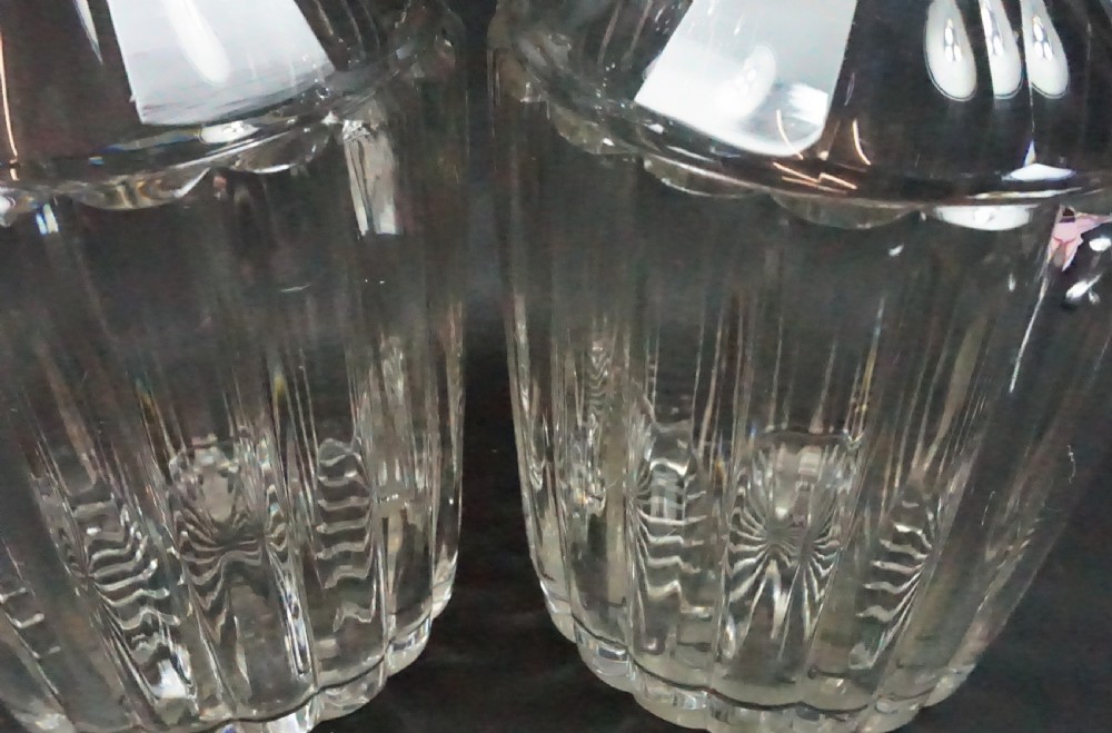 A pair of antique Regency clear cut crystal decanters featuring neck rings, vertical pillar cut bodies, and faceted stoppers. View II