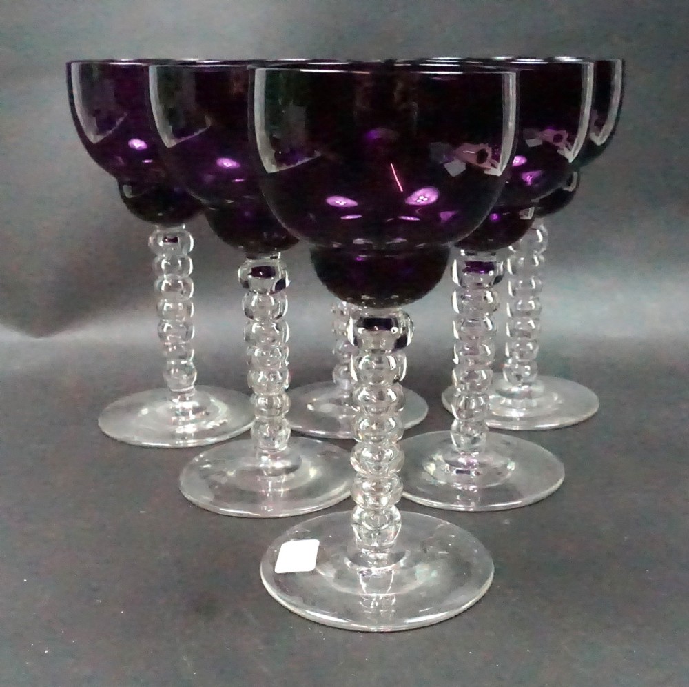 A set of six Victorian wine glasses featuring deep purple amethyst-coloured bowls supported by clear glass bobbin-turned stems.