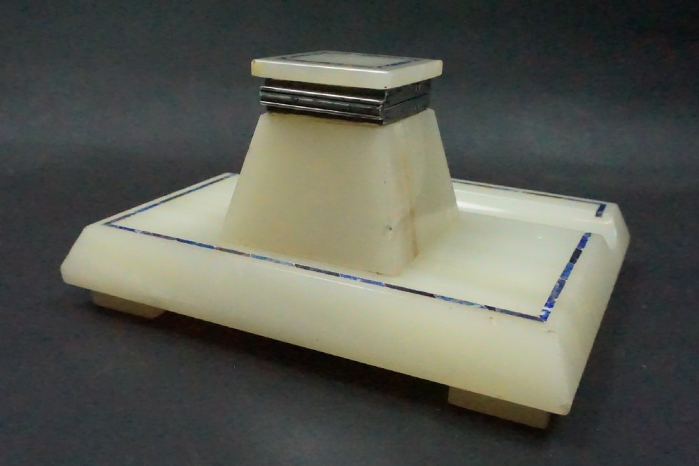 An Edwardian pale cream onyx inkstand featuring a central square inkwell with blue lapis lazuli inlay borders and silver mounts. View III